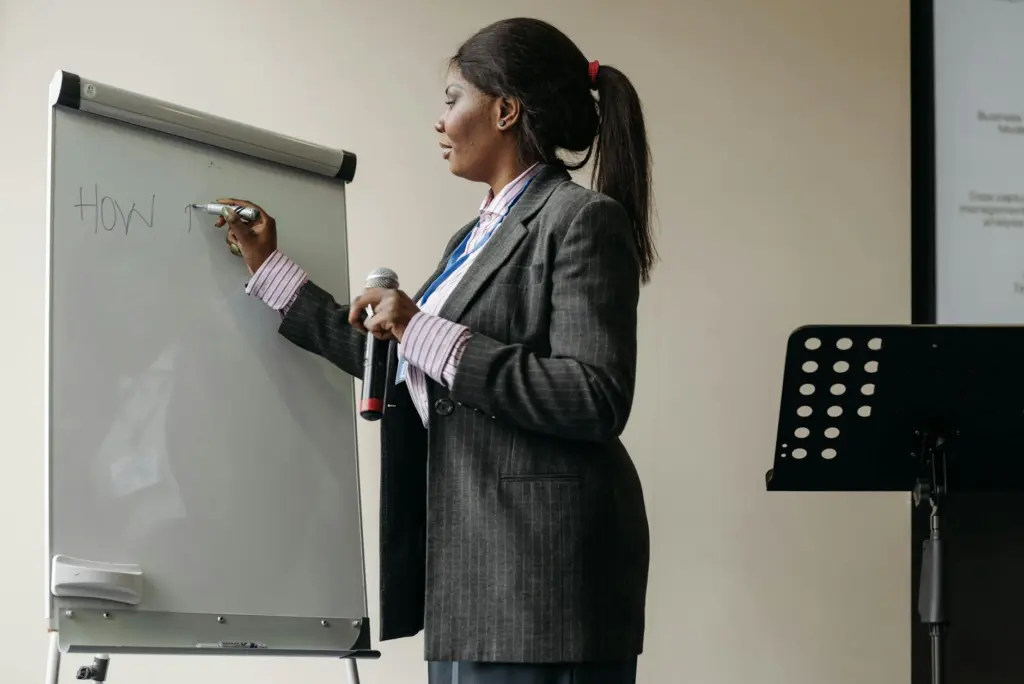 Confident businesswoman presenting ideas on a whiteboard during a seminar.
