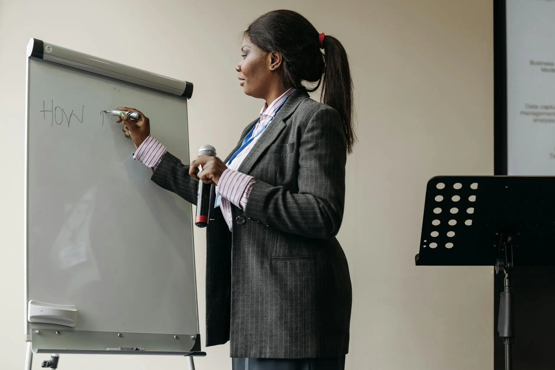 Confident businesswoman presenting ideas on a whiteboard during a seminar.